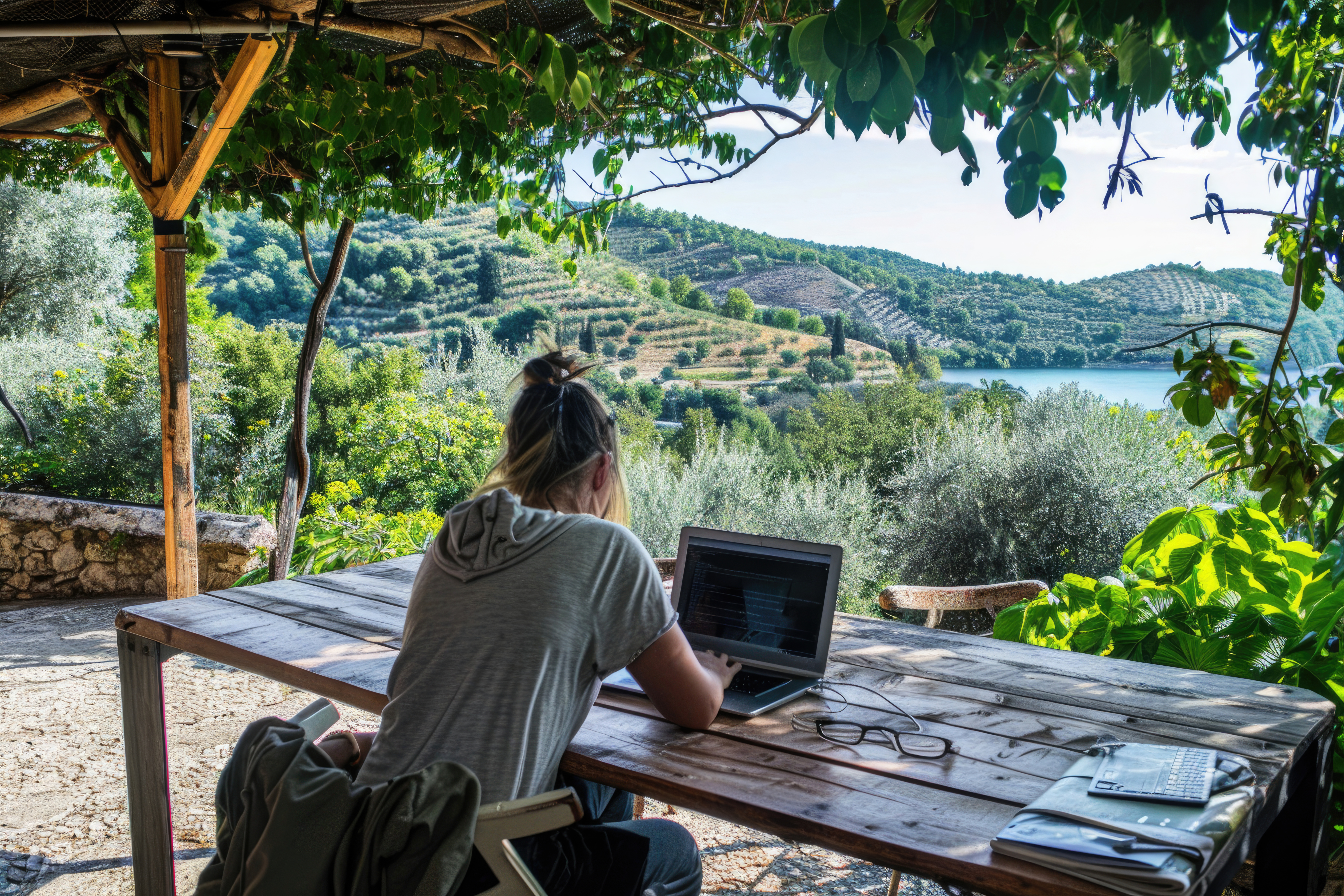 Remote professional working outdoors overlooking Mediterranean countryside